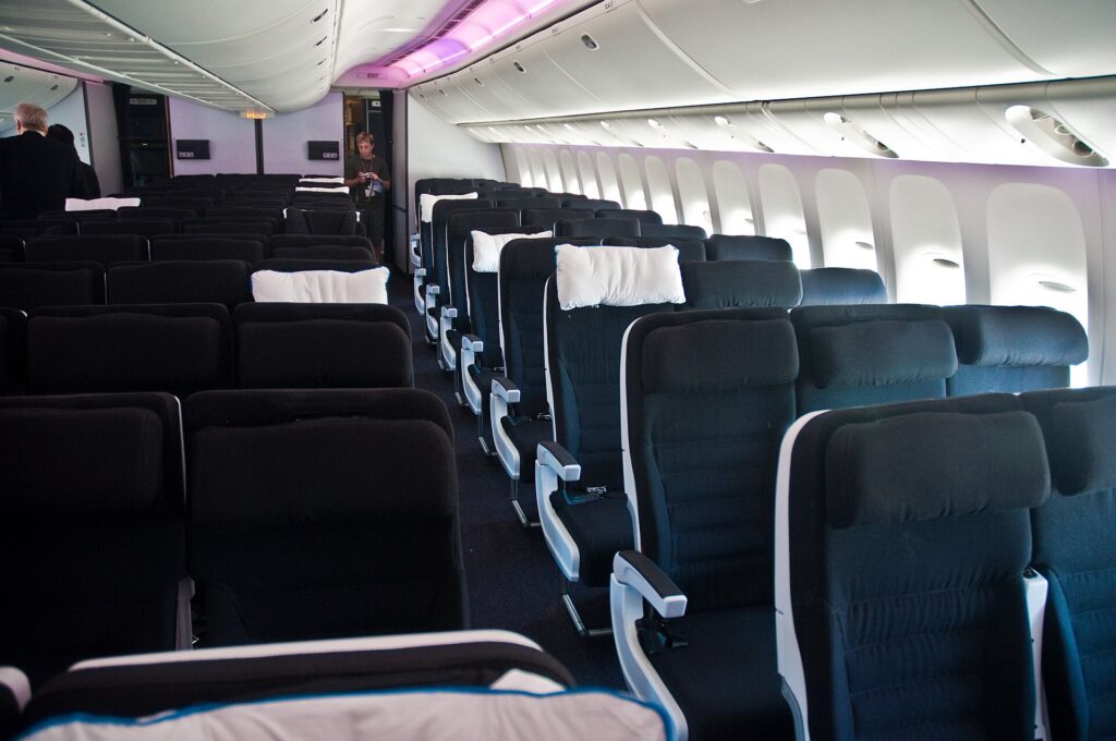 Economy cabin of an Air New Zealand Boeing 777-300ER with two aisles and seatback screens
