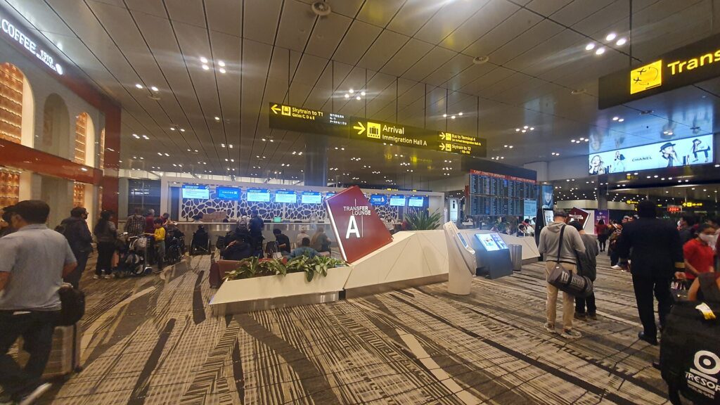 Airline transfer desk area at Singapore Changi Airport with passengers queuing
