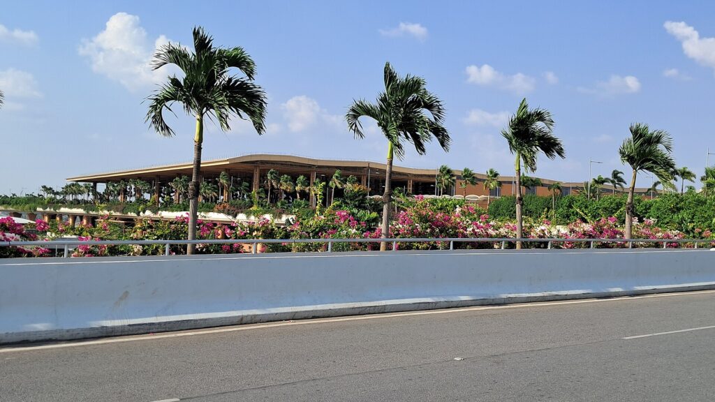Bengaluru Kempegowda International Airport Terminal 2 departures building with palm trees and flower beds