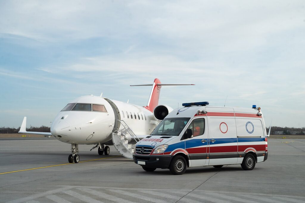 Bombardier Challenger 650 air ambulance jet parked next to a road ambulance