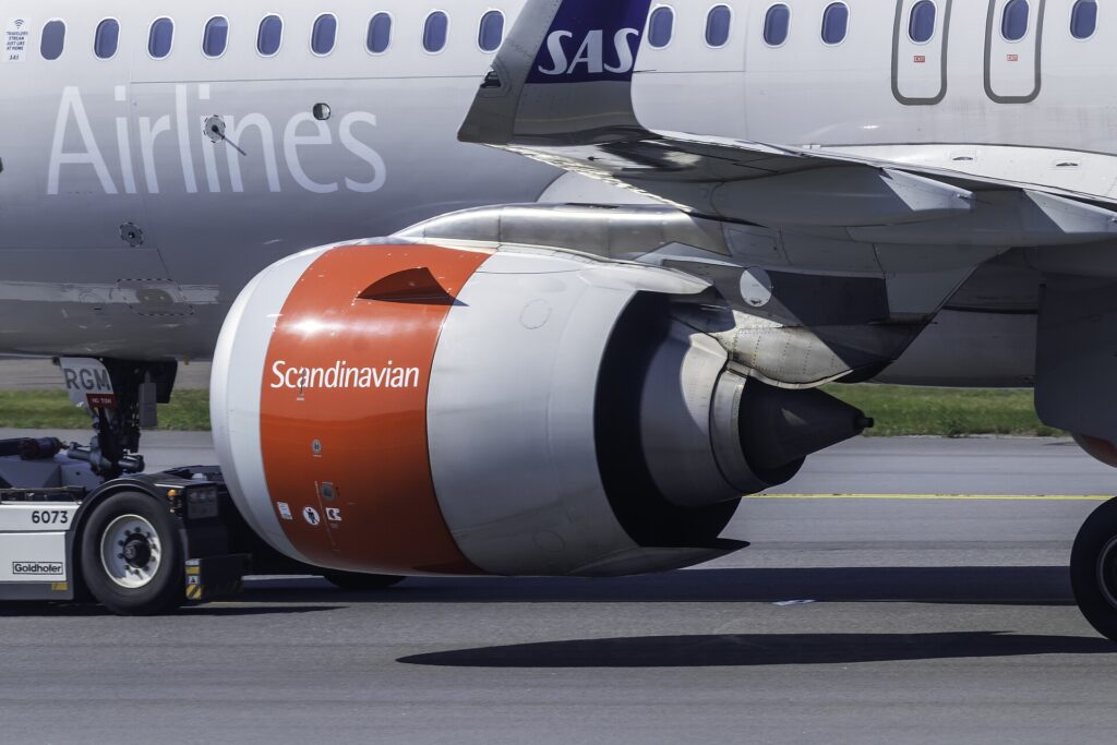 A CFM LEAP-1A engine with a red and white Scandinavian cowling under the wing of an SAS Airbus A320neo at Stockholm Arlanda