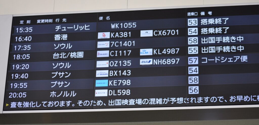 Fukuoka Airport departures board showing pairs of flight numbers such as KA381 with CX6701 and CI117 with KL4987