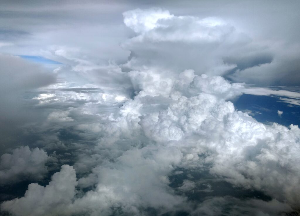 Towering cumulonimbus thunderstorm clouds seen from an airliner window