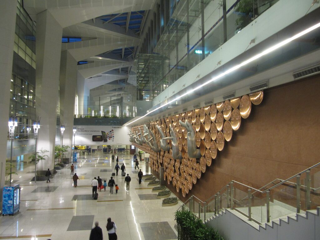 Inside Terminal 3 at Indira Gandhi International Airport, Delhi, with a large wall of copper discs above the hall