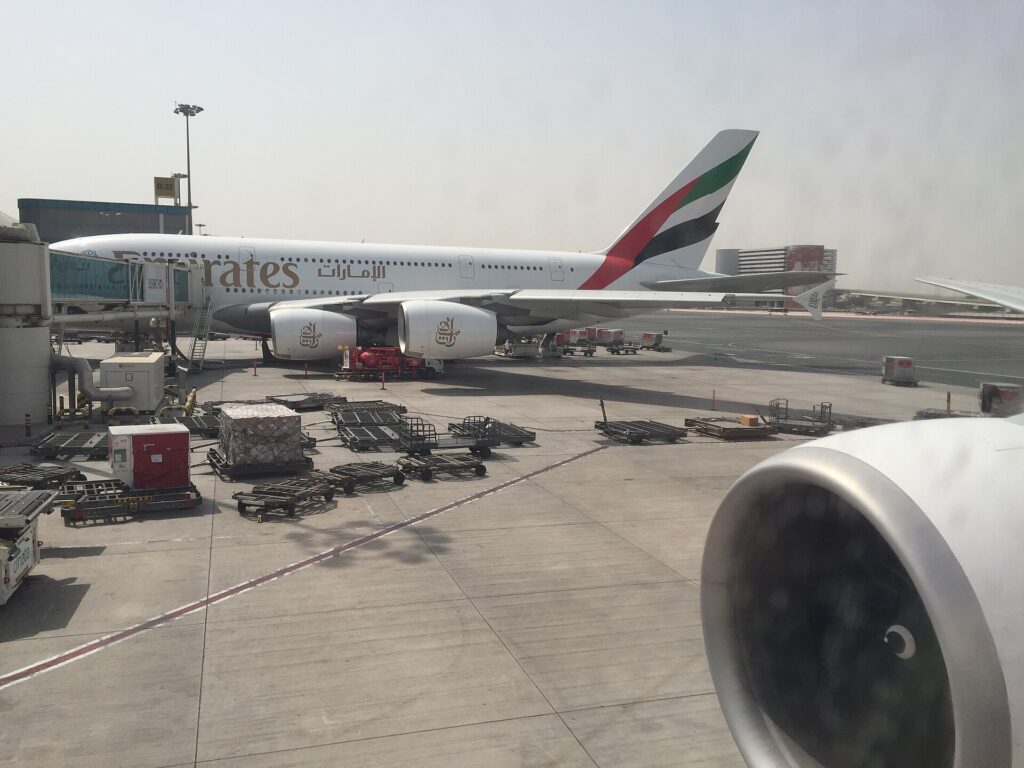 Emirates Airbus A380 parked at a gate at Dubai International Airport, seen from another aircraft