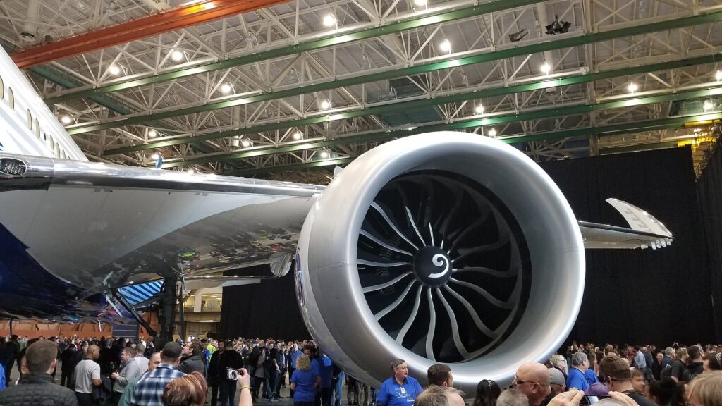 GE9X engine under the wing of the first Boeing 777-9, with a crowd of people standing below it