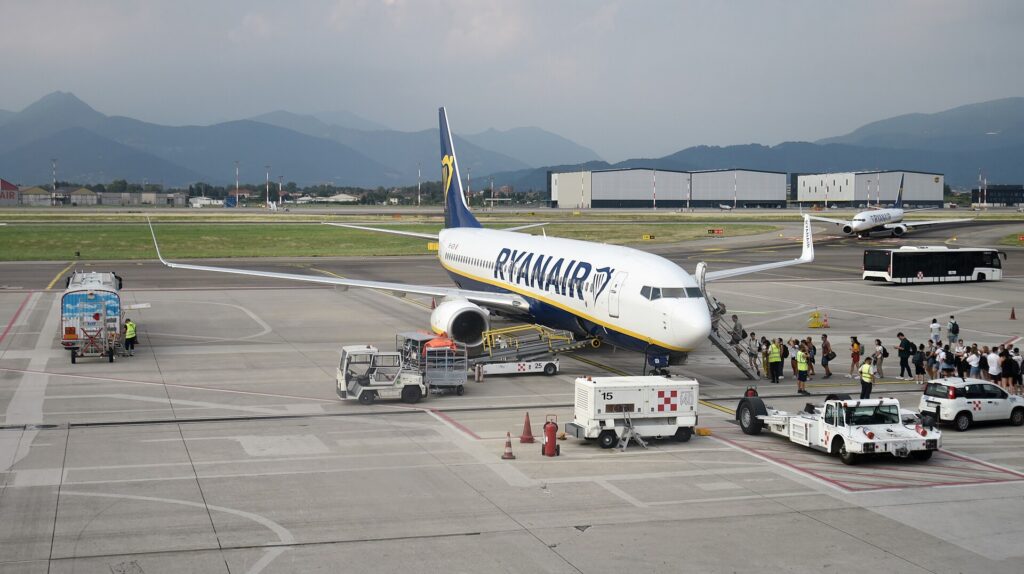 A Ryanair-liveried Malta Air Boeing 737-800 parked on the apron at Milan Bergamo with passengers walking to the front stairs