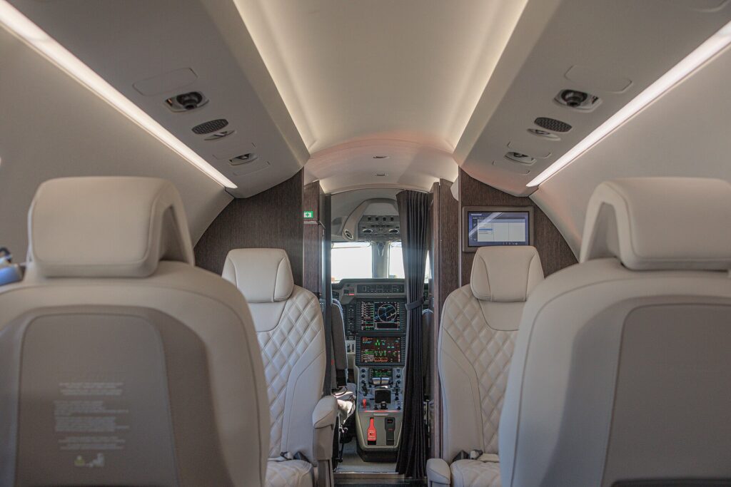 Pilatus PC-24 cabin with cream leather seats and the cockpit visible at the front