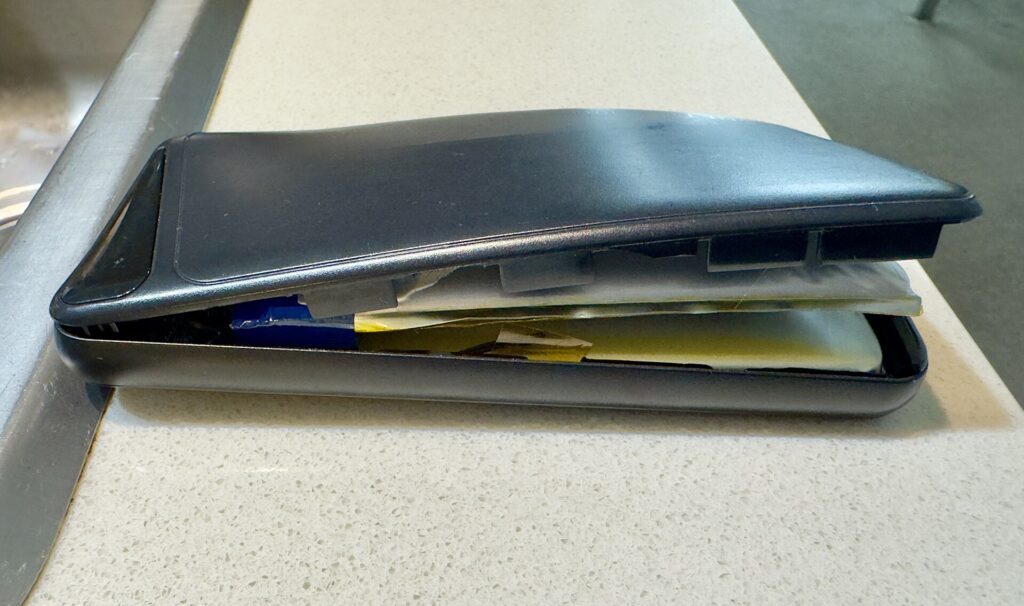 A power bank whose case has split open because the lithium battery inside has swollen