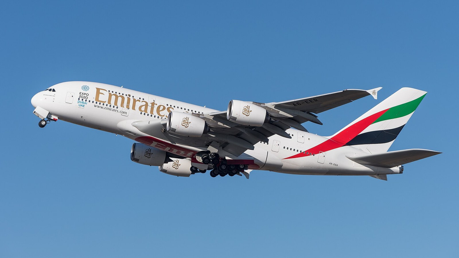 Emirates Airbus A380 widebody aircraft climbing after take-off against a blue sky